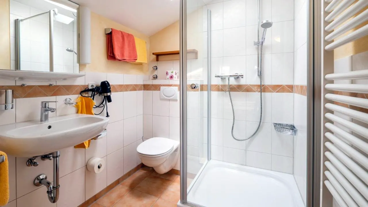 Bad mit Dusche, Waschbecken und Handtuchheizkörper