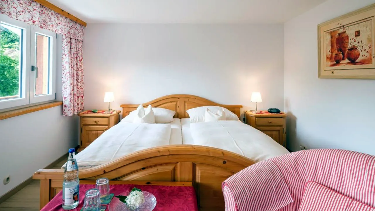 Doppelzimmer mit Kiefernbett und rot-weiß gestreiftem Sessel